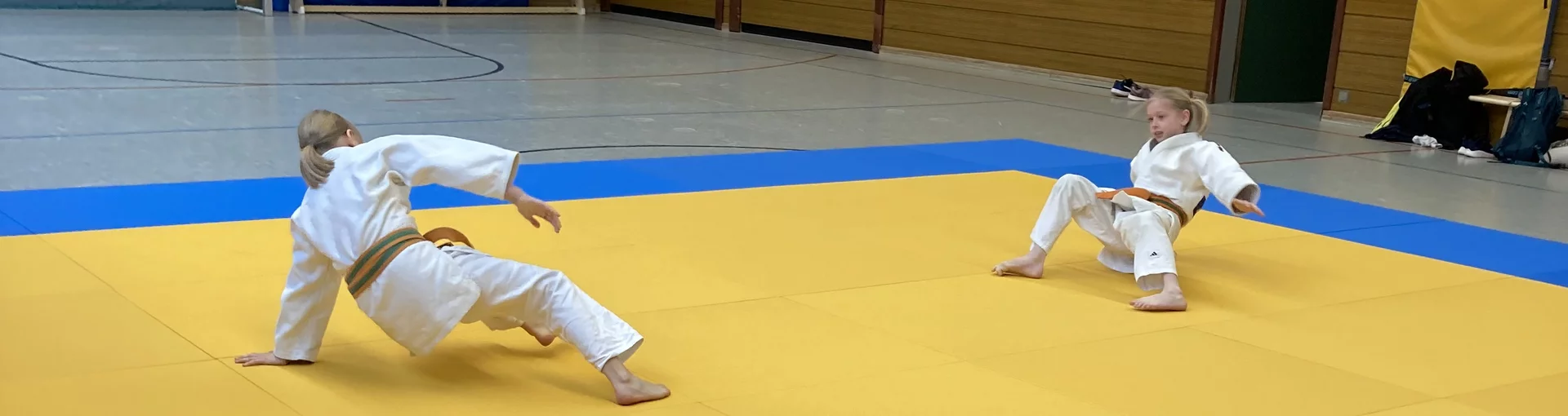 Zwei Judokakinder die sich auf der Judomatte aufwärmen