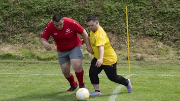 Auf dem Bild sind zwei Fußballspieler abgebildet, die um einen Ball kämpfen.