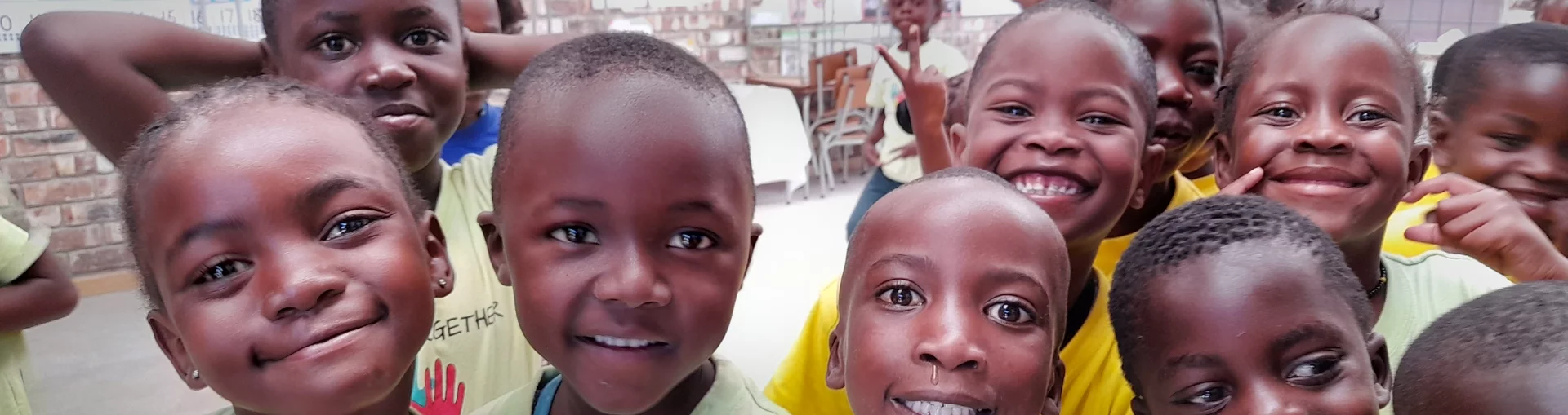 Das Bild zeigt afrikanische Kinder, die vor Freude strahlen.