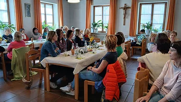 Auf dem Bild sind eine Gruppe von Frauen abgebildet, die alle gemeinsam auf einem Tisch sitzen.
