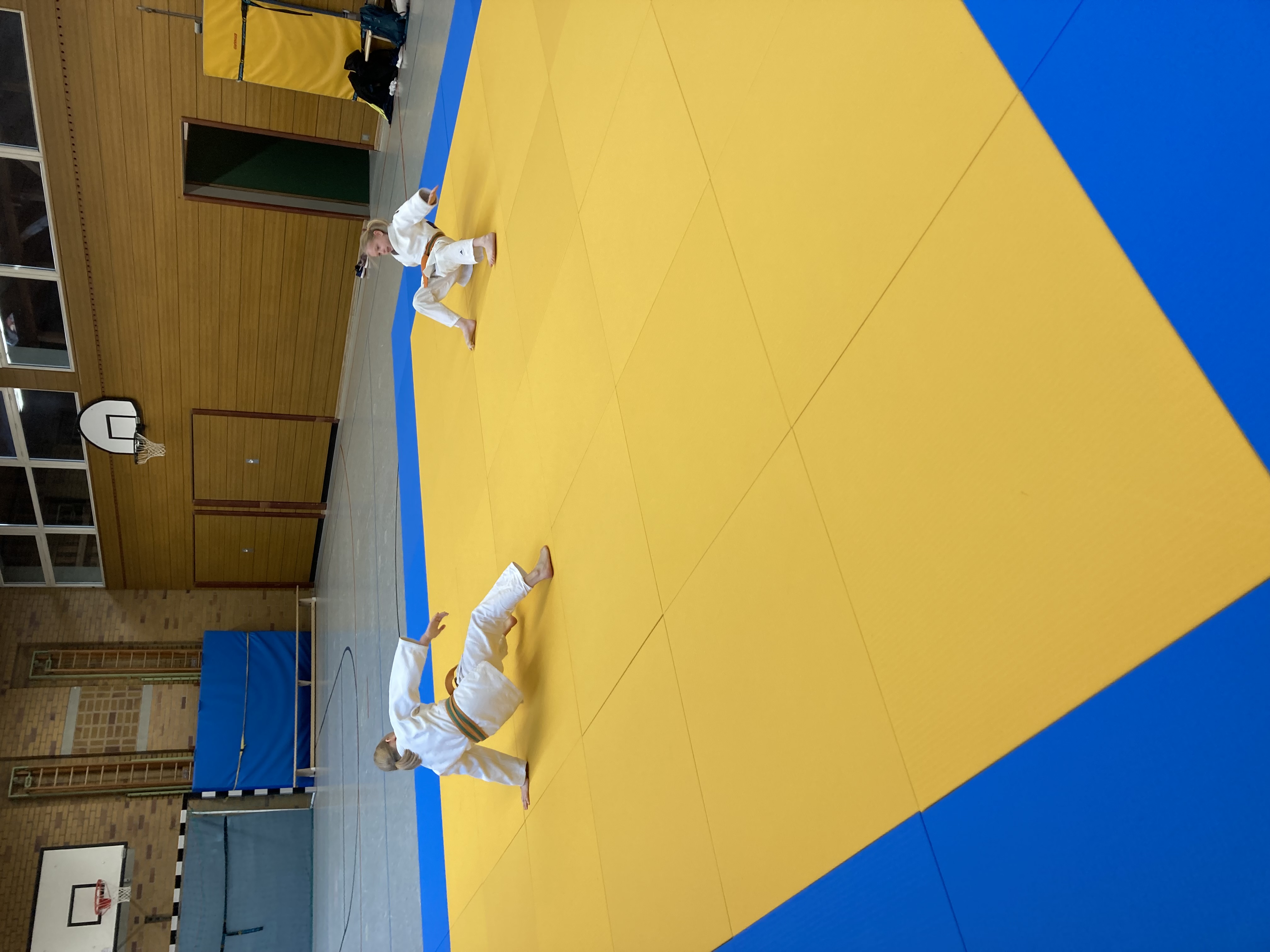 Zwei Judokakinder die sich auf der Judomatte aufwärmen