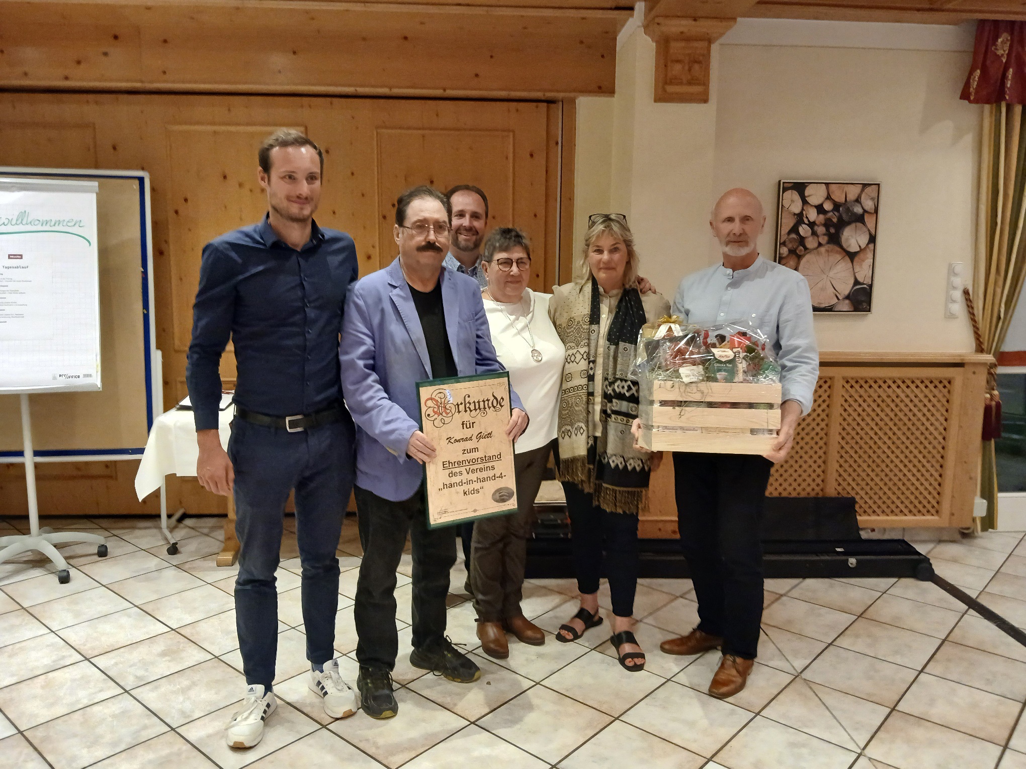 Auf dem Bild ist die neue gewählte Vorstandschaft (von links nach rechts: Simon Staschewski (1. Vorsitzender), Konrad Gietl (Ehrenvorsitzender) Markus Kellner (Kassier), Renate Poeplau (Kassenprüferin), Johannes Wagner (2. Vorsitzender) des Vereins "hand-in-hand-4-kids" abgebildet. Auf dem Bild ist ebenso Anja Rohwer abgebildet (die Hauptansprechpartnerin der beiden Projekte vor Ort in Namibia)